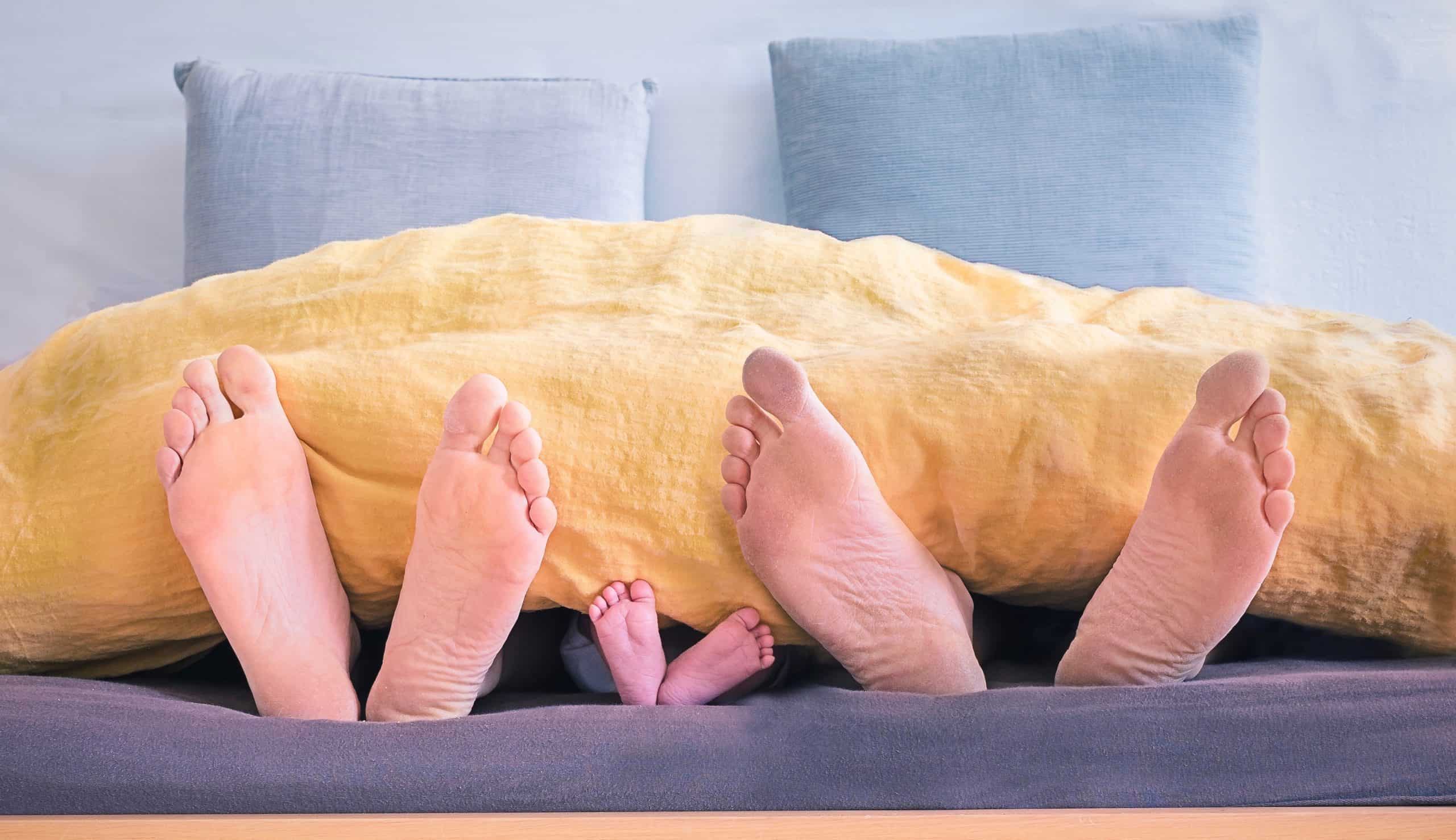 Family's feet sticking out of a blanket having a staycation with kids
