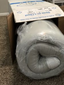 puffy mattress rolled in shipping box