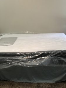 puffy mattress fresh out of the box, with plastic wrap still on it. 