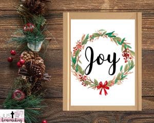 Christmas wall art printable that reads "Joy" with a wreath around it