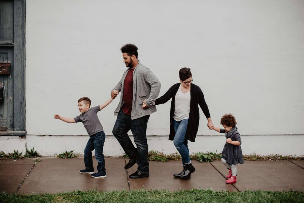 Dad, Mom, and kids holding hands having a Family Sabbath