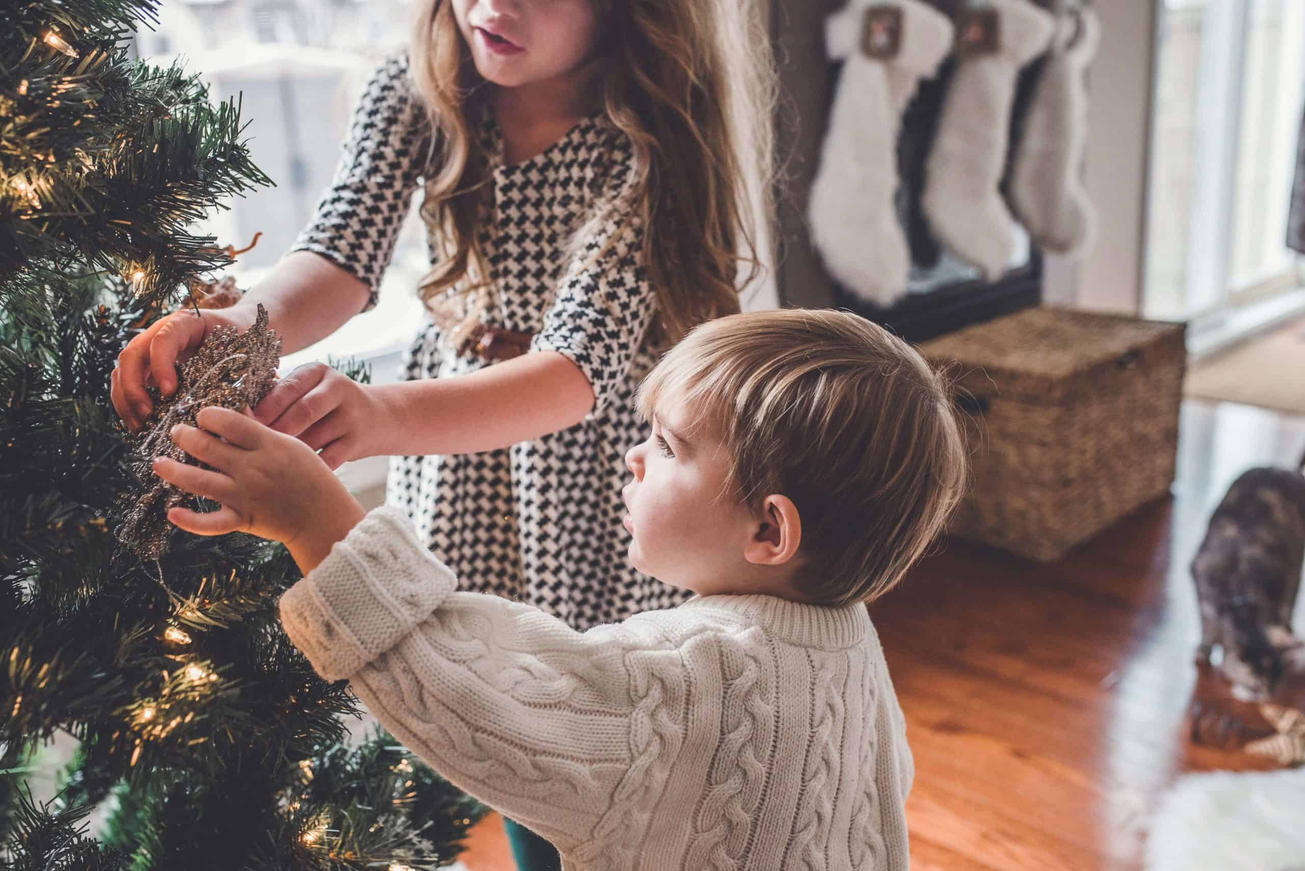children making memories at christmas by decorating the tree together