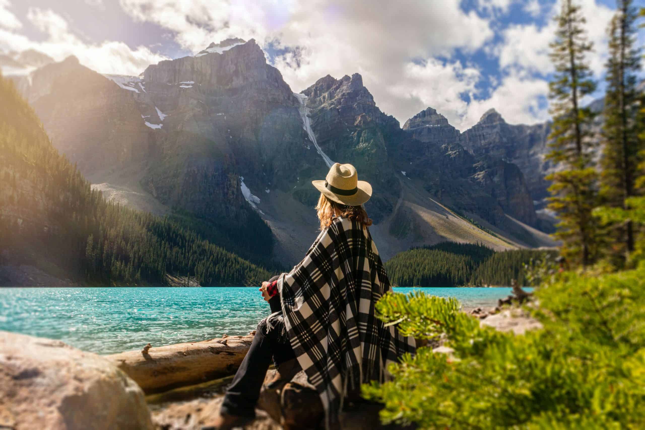 woman enjoying the beautiful outdoor mountain air next to a stream