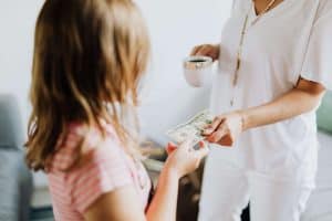 mom giving her daughter money for allowance
