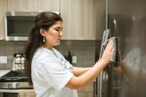 Woman wiping down fridge