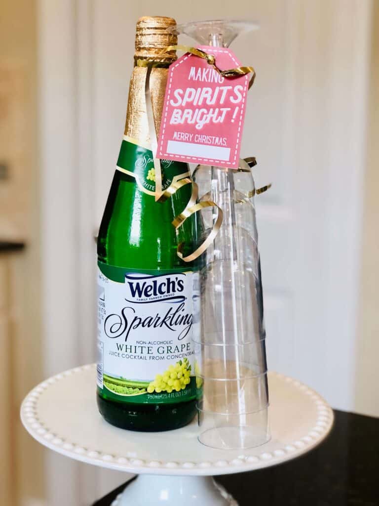 Christmas Ding Dong Ditch Idea from Just Homemaking: Bourbon or sparkling grape juice with plastic champagne flute glasses and gift tag "Making Spirits Bright! Merry Christmas!"
