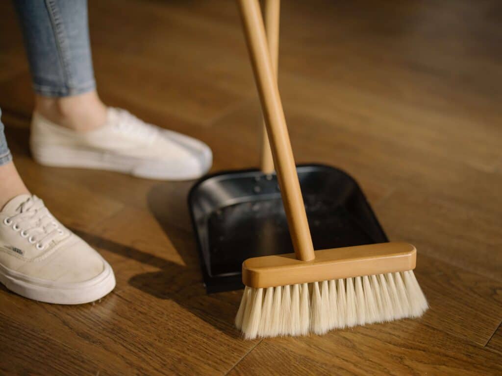 broom sweeping into a dust pan