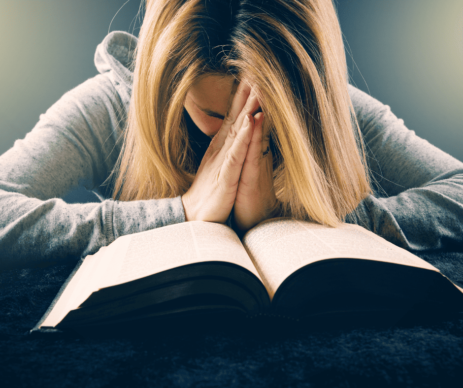 Woman praying over the Bible: learning about intentional homemaking