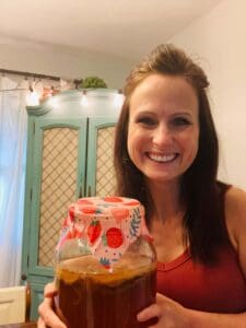 woman holding jar of kombucha covered with beeswax wrap