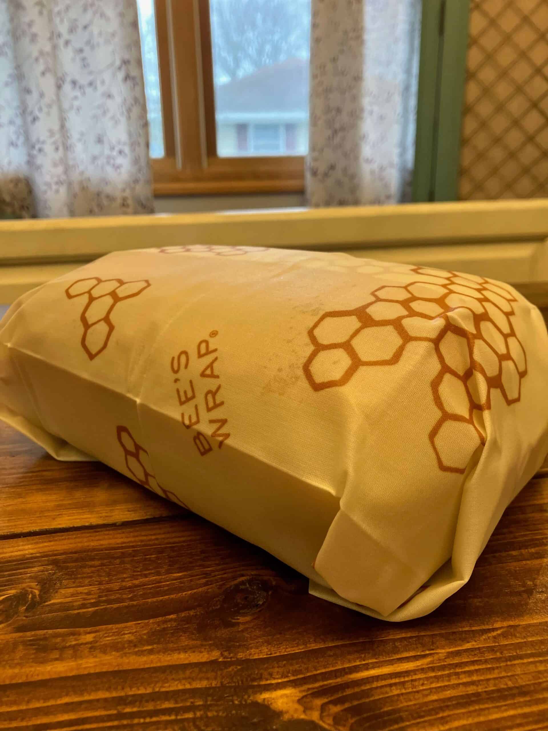 loaf of bread wrapped in beeswax wrap laying on a table