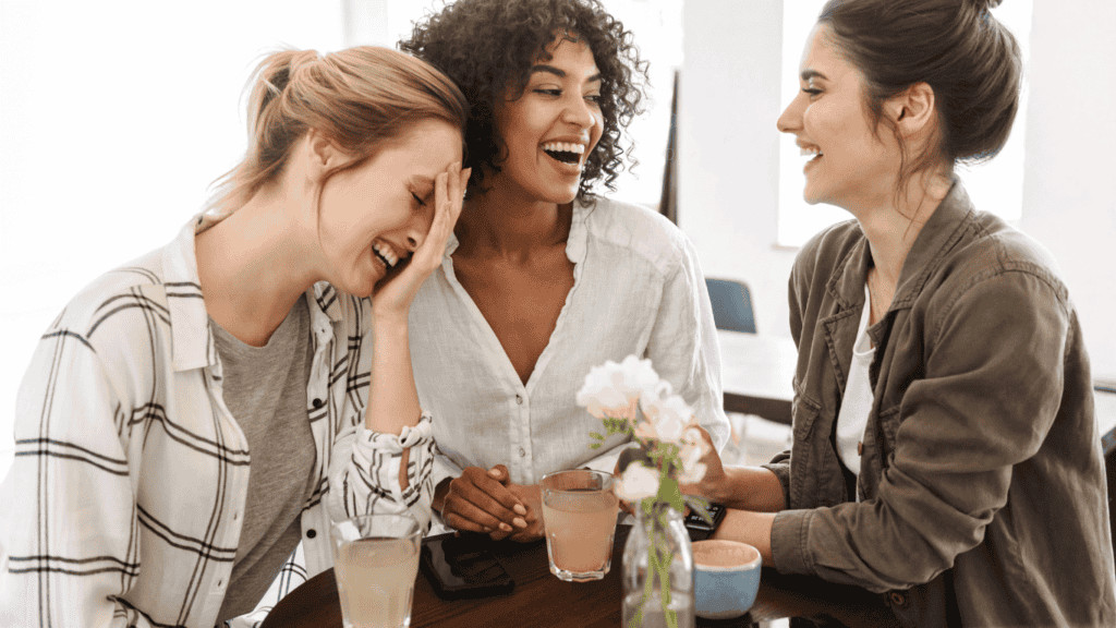 How to enjoy homemaking: Embrace community. Three female friends laughing and talking over coffee.