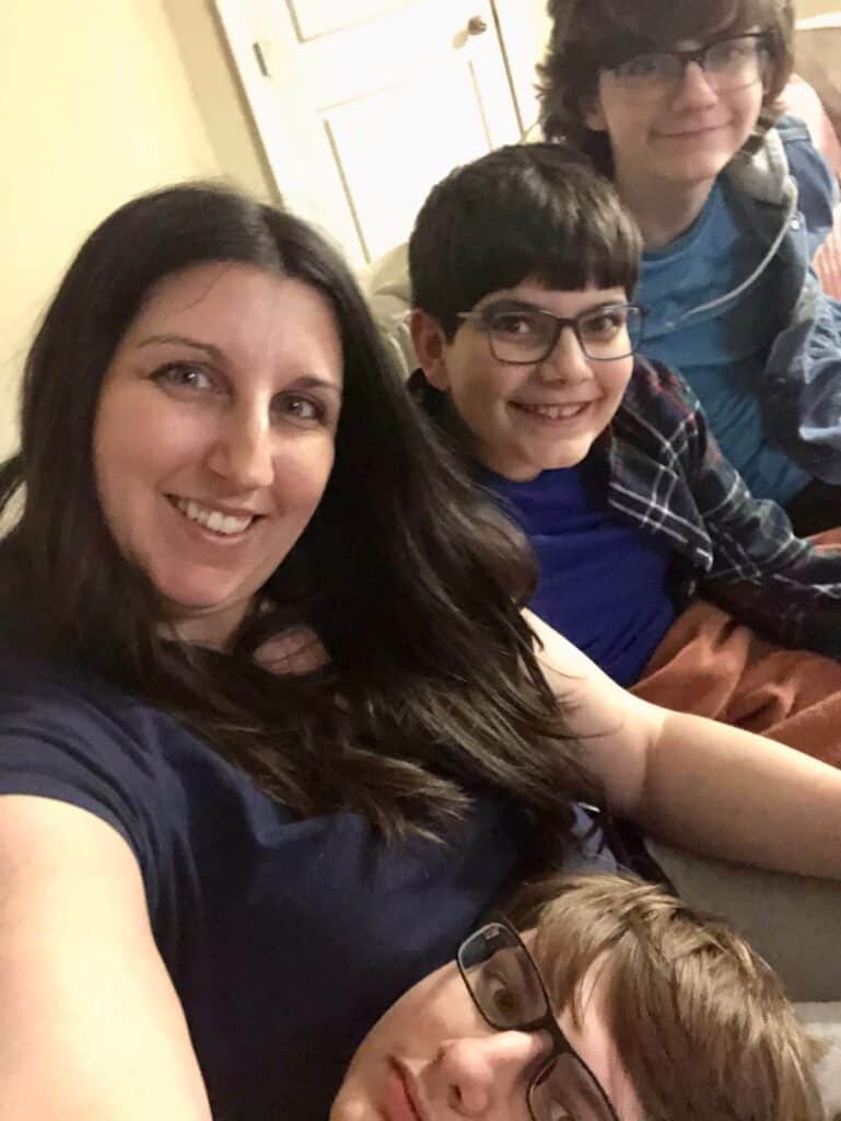 What no one tells you about raising teen sons: You'll want to hang out with them. (Mom and three sons hanging out on the couch.)