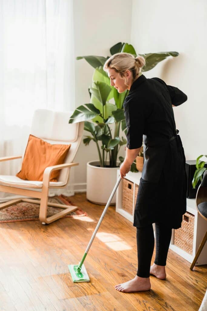 My morning cleaning routine: Dry mop/sweep/vacuum high traffic areas. (woman dry mopping a wooden floor)