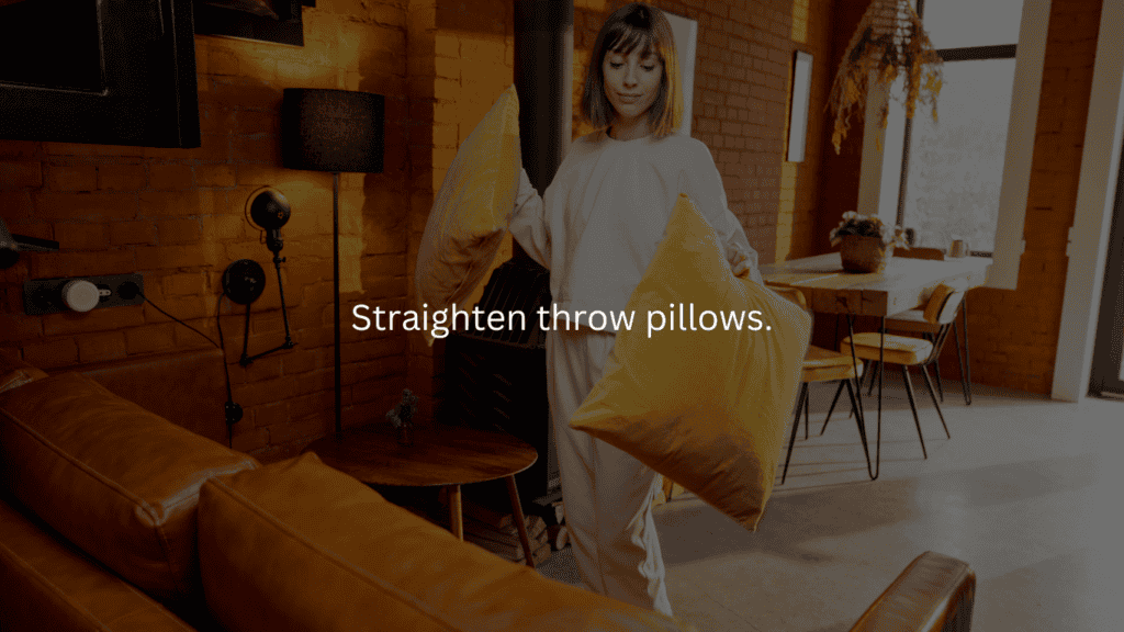 Nightly cleaning routine: straighten throw pillows. Woman straightening 2 yellow pillows on a couch. 